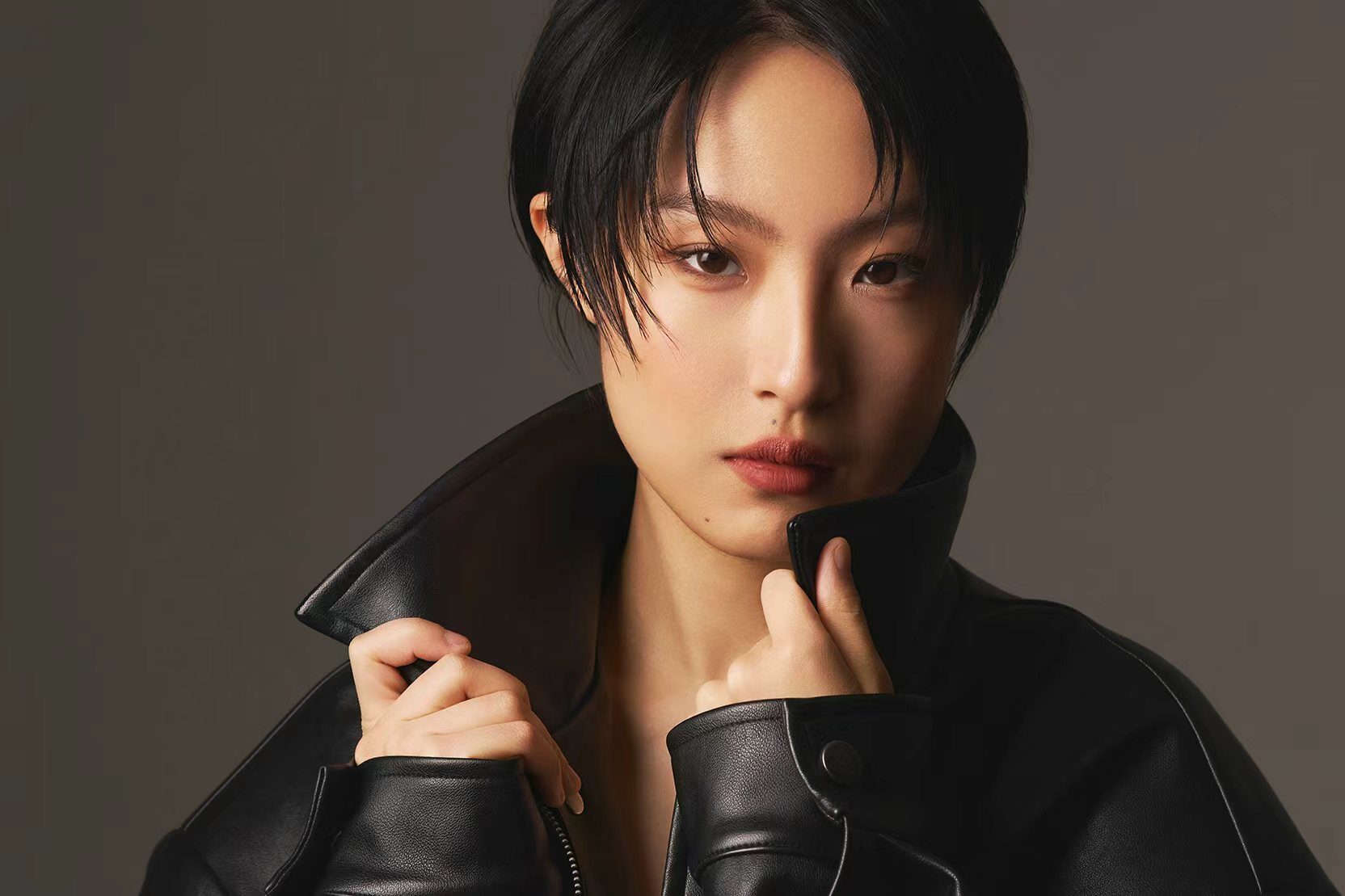 Portrait in a black leather jacket, holding the collar